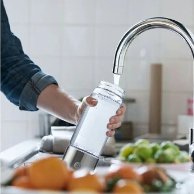 Filling the AquaFusion bottle with tap water at a kitchen sink