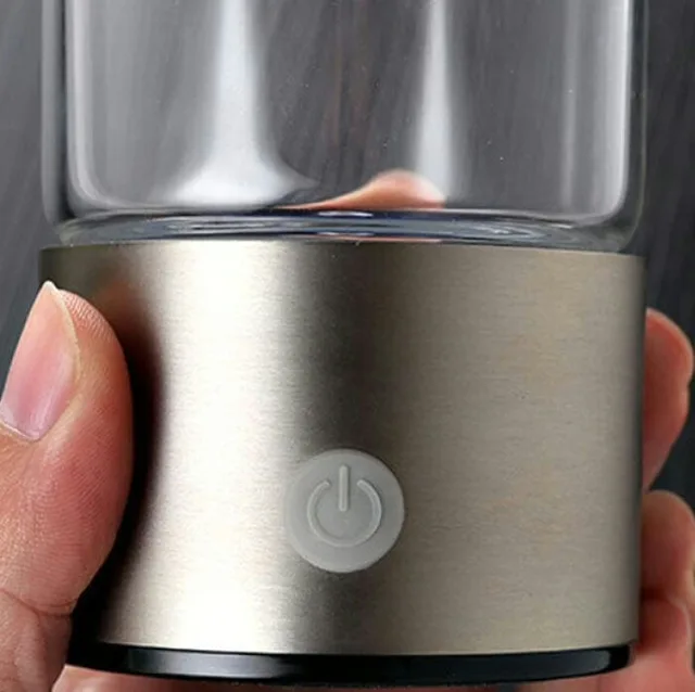 Close-up of a hand holding the AquaFusion stainless base with its power button