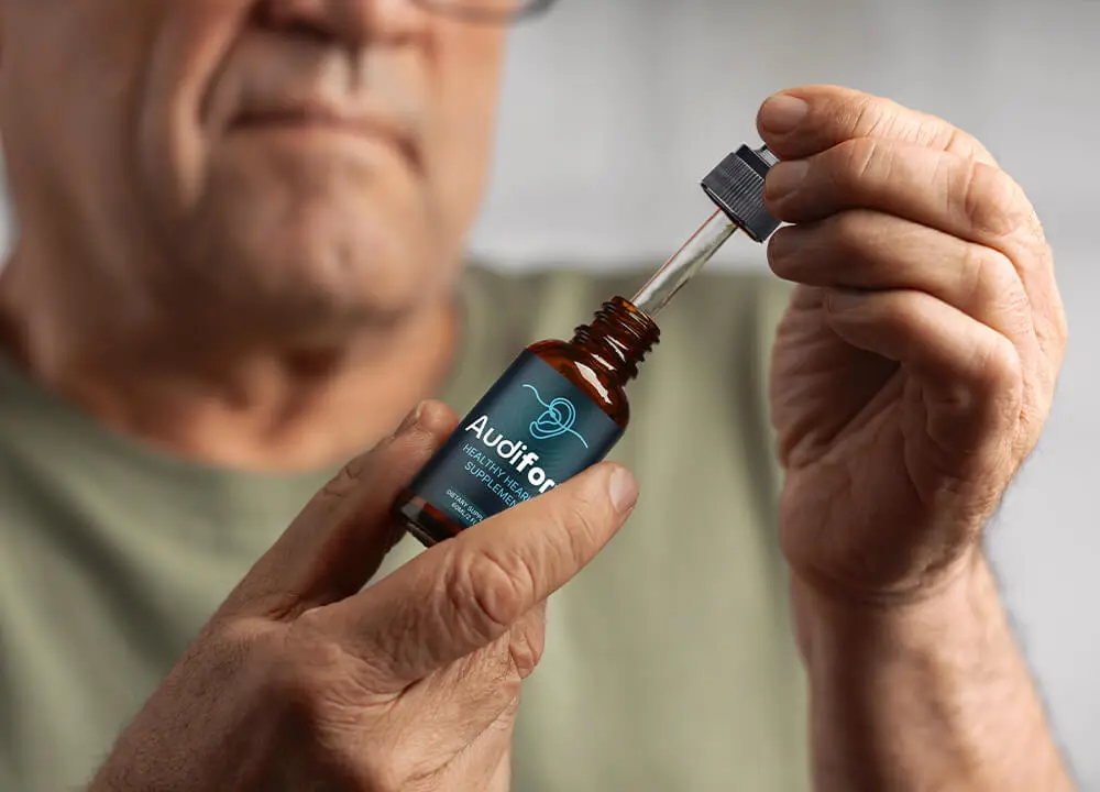A pair of hands opening the amber glass dropper bottle of Audifort, the seller's own product photo