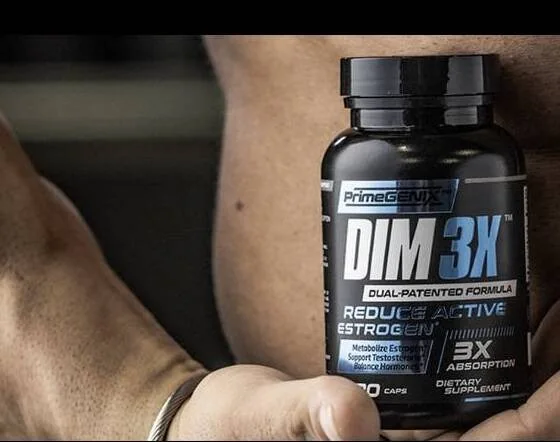 A hand holding the PrimeGENIX DIM 3X bottle against a dark gym background; the label reads DIM 3X, Dual-Patented Formula, 90 caps, dietary supplement