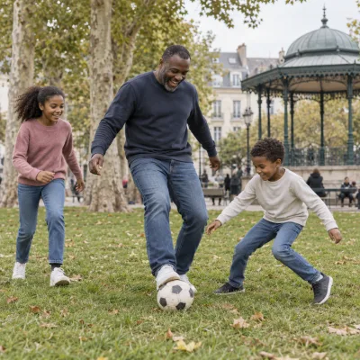 Un homme d'une quarantaine d'années rit en jouant au football avec ses deux enfants sur la pelouse d'un parc