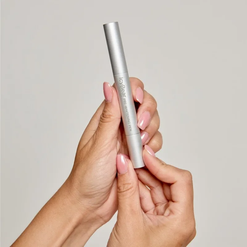 Two hands holding the silver Icy Bear Pre-Whitening Pen, manufacturer's product photo
