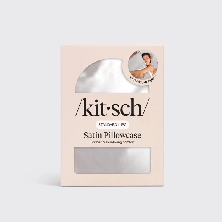 The Kitsch retail box for the Satin Pillowcase, pale pink with a window showing the silver fabric, printed STANDARD 1PC, the vendor's line For hair and skin-loving comfort and a round sticker reading Seriously, so soft