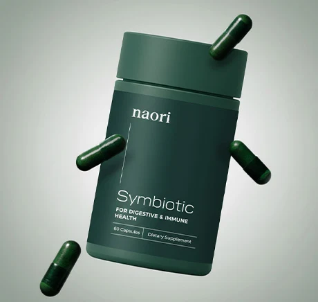 The manufacturer's own photo of the Naori Symbiotic bottle with loose capsules around it; the label reads naori Symbiotic, For Digestive & Immune Health, 60 Capsules, Dietary Supplement