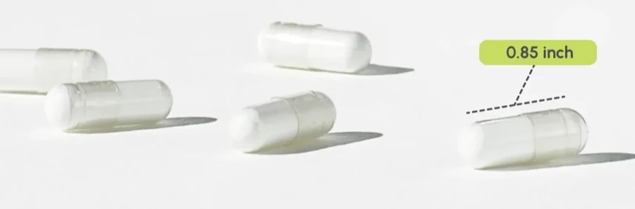 Cinque capsule bianche partiQlar su una superficie chiara, una indicata come 0,85 pollici