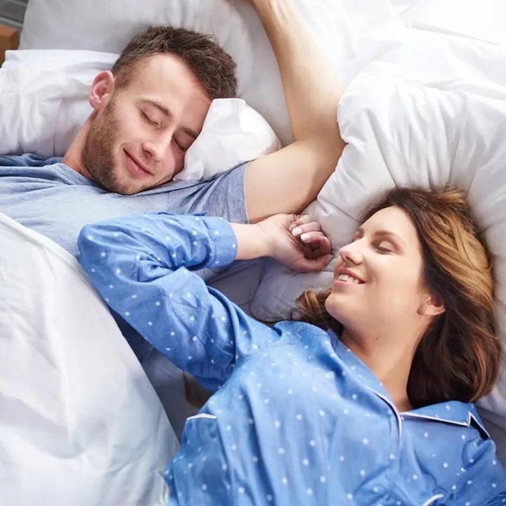 Couple lying in bed together, smiling