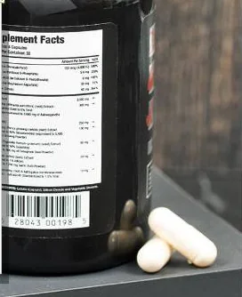 Produktfoto des Herstellers: die Testosil-Flasche steht auf einer Steinplatte, das Feld Supplement Facts und der Strichcode sind sichtbar, daneben liegen zwei weiße Kapseln
